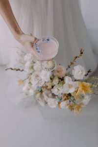 Sustainable Wedding Signature Cocktail held over a bunch of wedding flowers