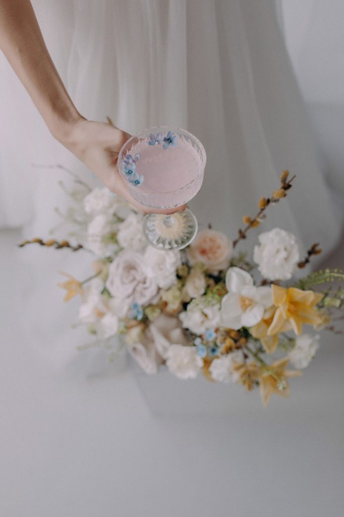Sustainable Wedding Signature Cocktail held over a bunch of wedding flowers