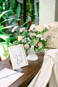 Wedding Guest book and vase of flowers sitting on a table