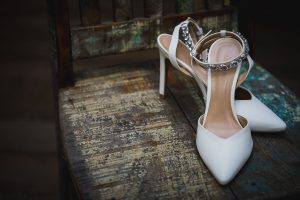 Pair of wedding shoes sitting on a wooden bench