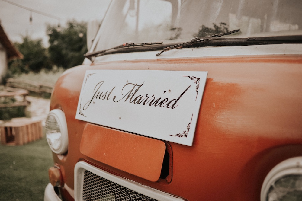 Just Married sign on the front of an orange van