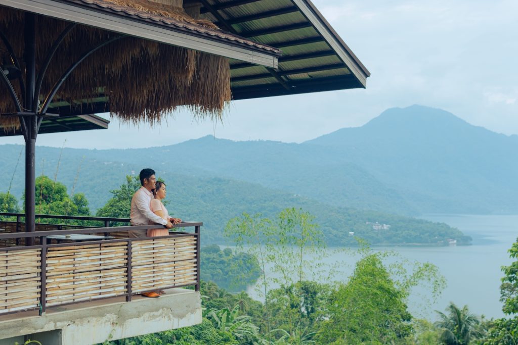 Couple standing at the edge of a balcony on their ethical honeymoon