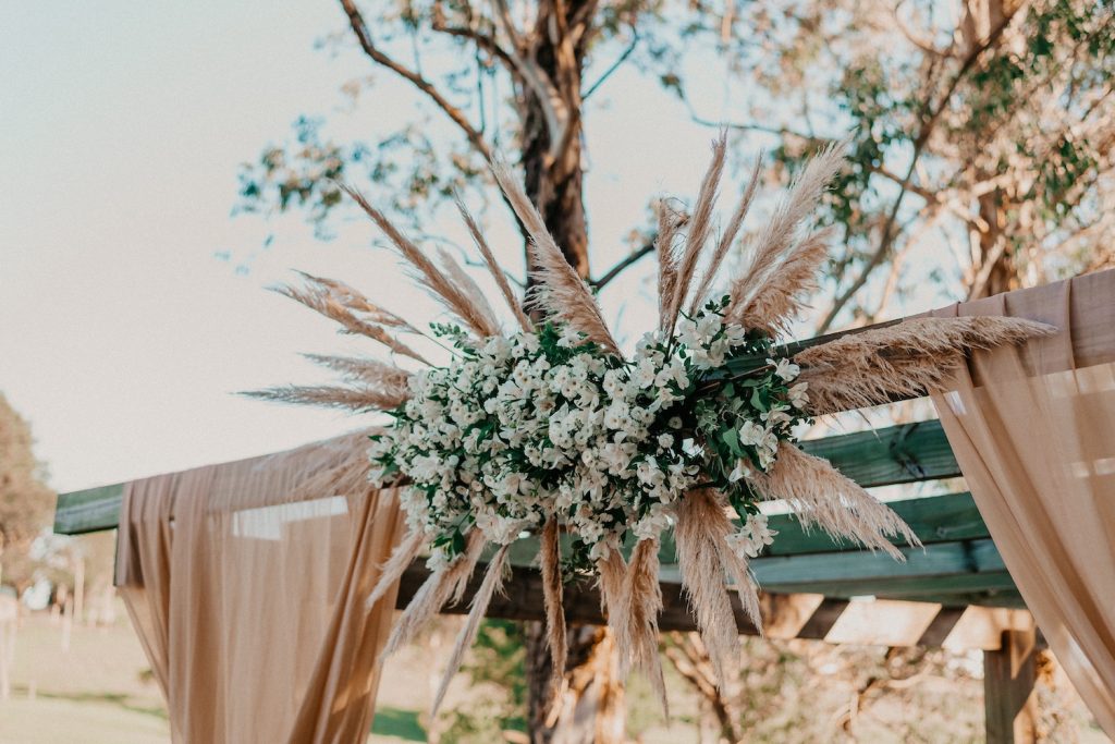 A bunch of sustainable wedding flowers attached to a wedding arbor
