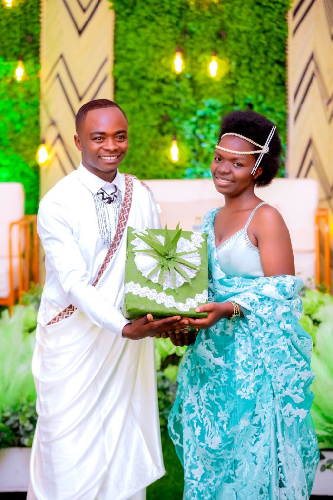 Bride and groom holding a green wedding gift