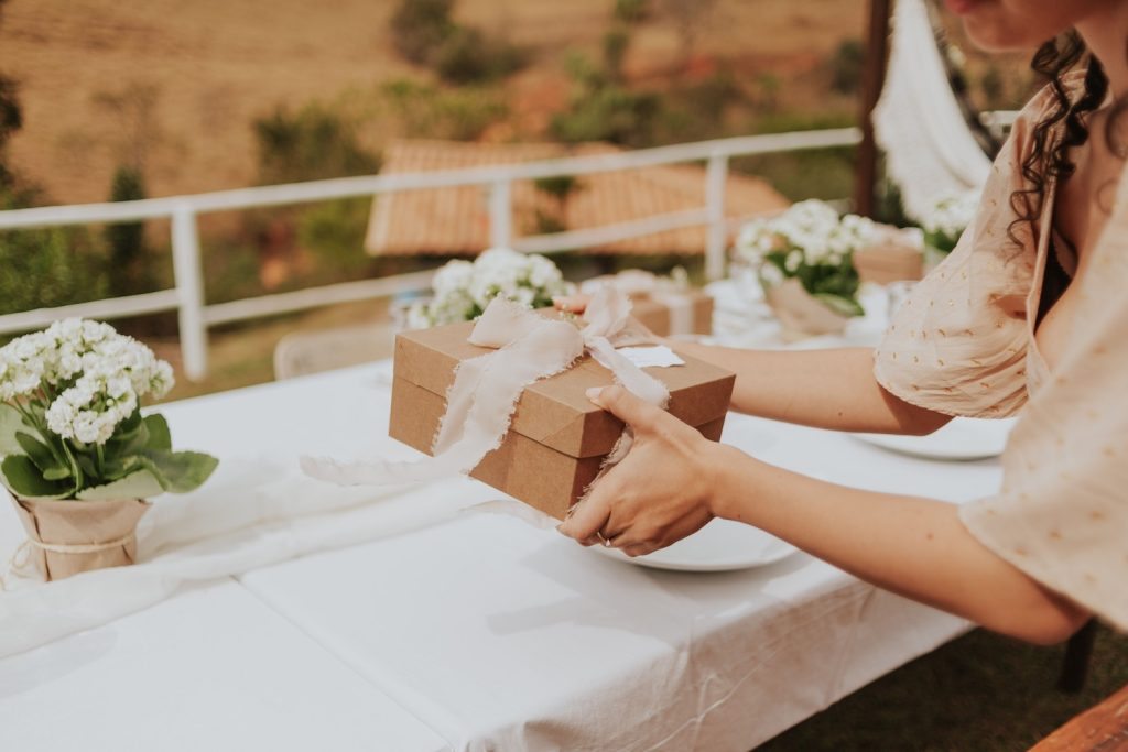 Person holding onto an eco-friendly gift at a table