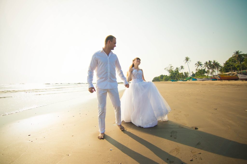 Bride and groom walking along the beach at their destination wedding