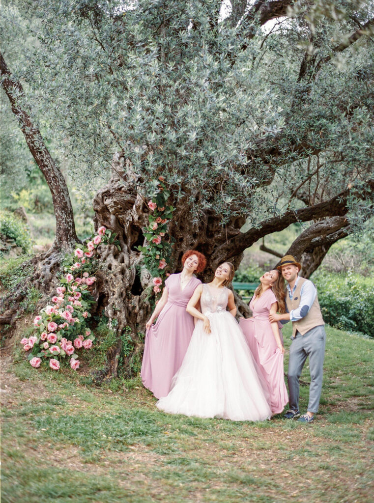 Bridal party standing in front of a tree at their sustainable wedding