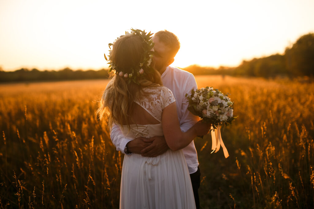 Bride and groom kissing in the middle of an autumn field