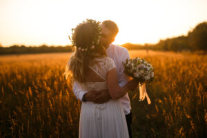 Bride and groom kissing in the middle of an autumn field