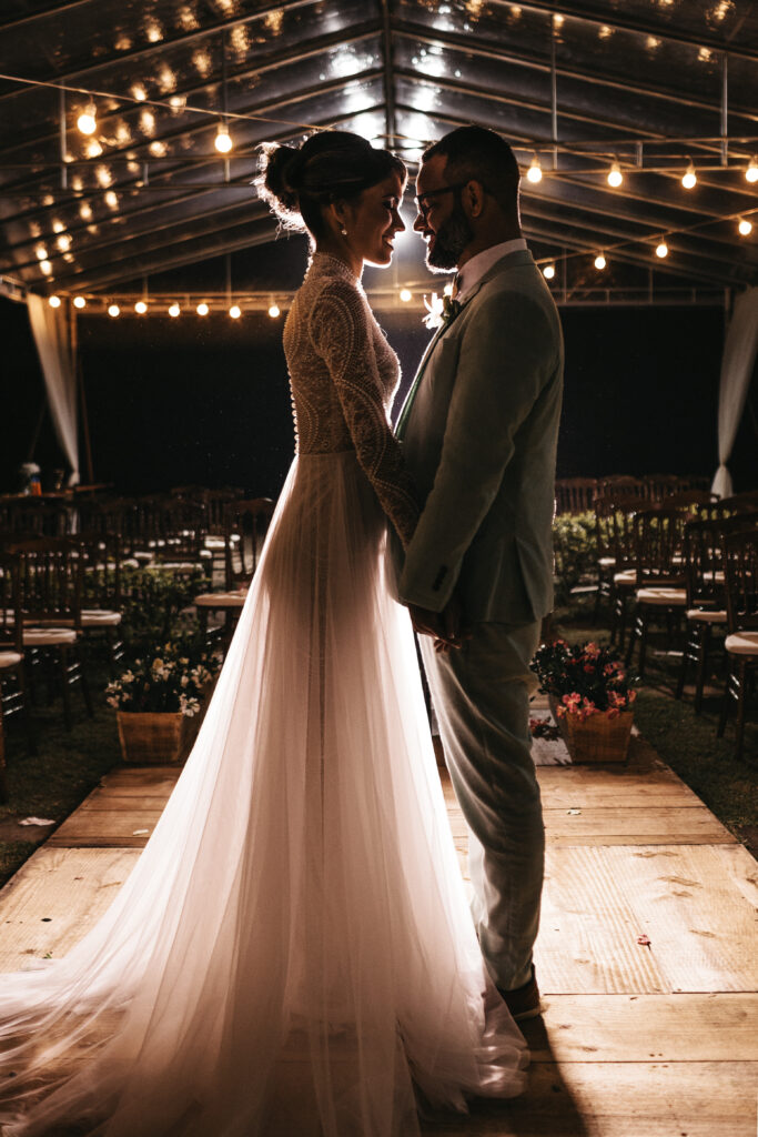 Bride and groom standing facing each other holding hands on their wedding day