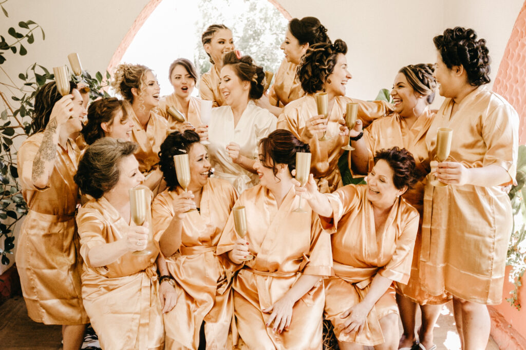 Large bridal wedding party in pale pink satin wraps