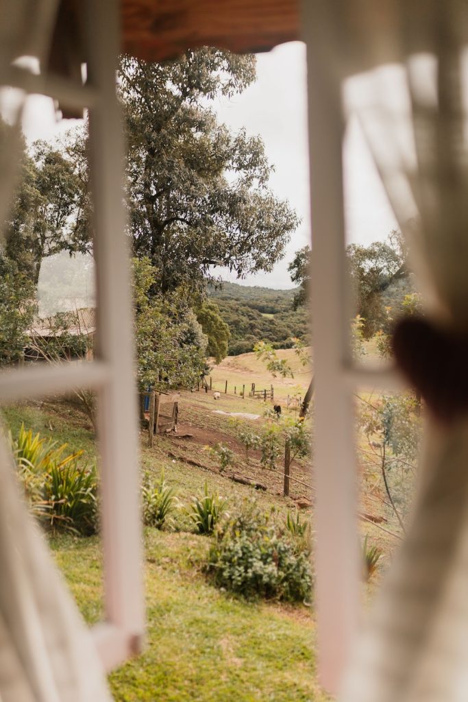 View looking out an open window to a field beyond at a sustainable wedding accommodation