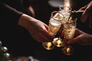 Three champagne glasses getting filled by a person during a bottle of champagne