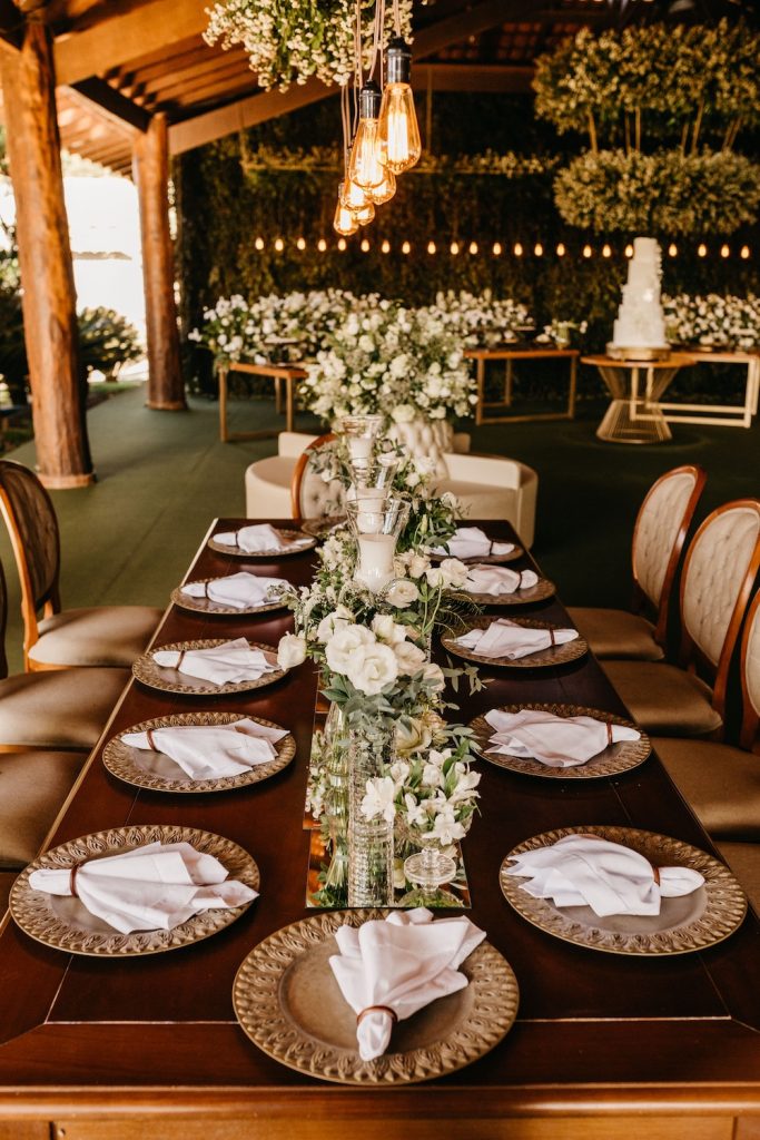 Wedding table display set with plates and cutlery and centrepieces of flowers in an old barn
